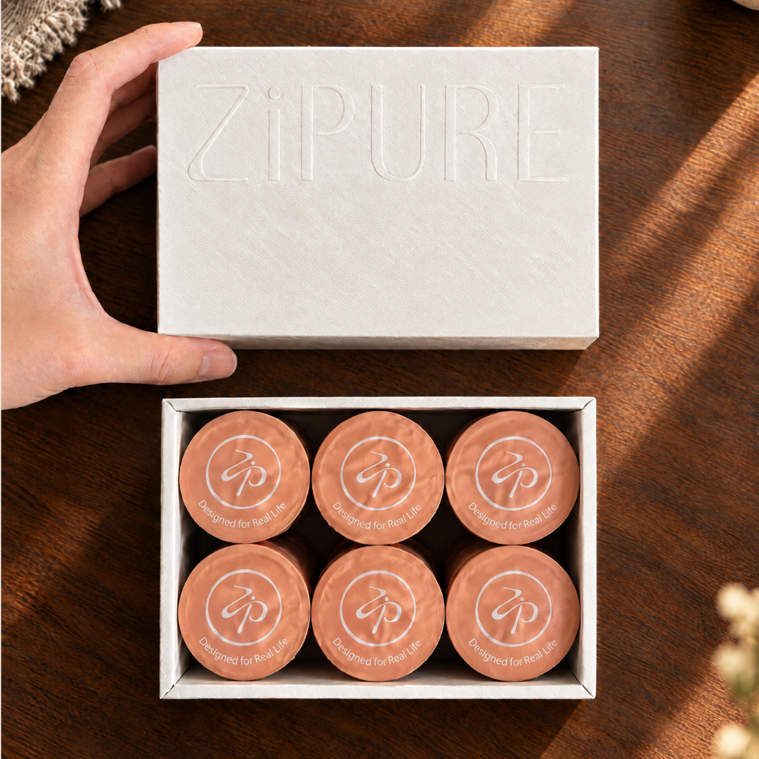 Hand opening a ZIPURE Always Smooth Black box revealing six coffee pods