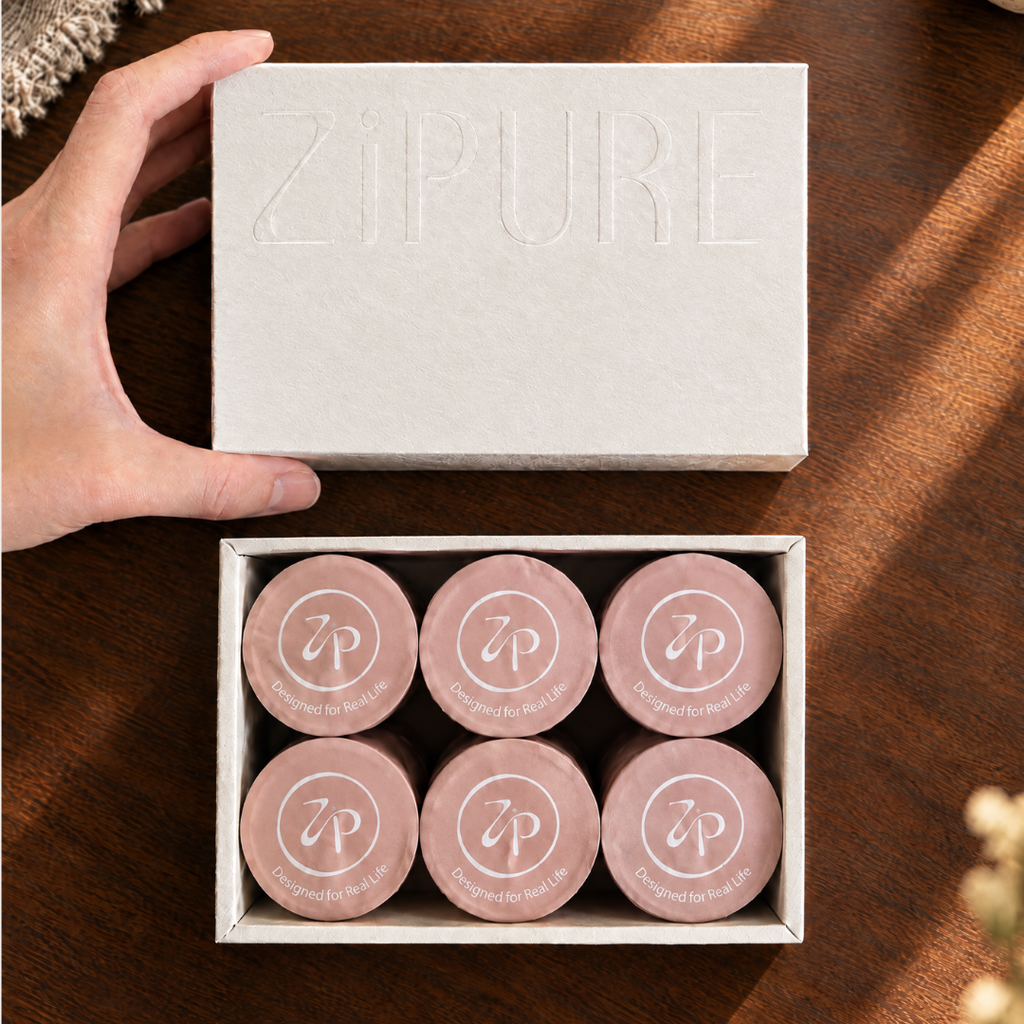 Hand opening a ZIPURE Never Bitter Shot box revealing six coffee pods