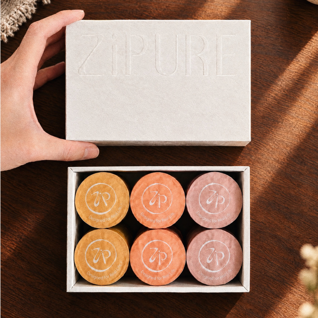Hand opening a ZIPURE No Bad Coffee Set box revealing six coffee pods
