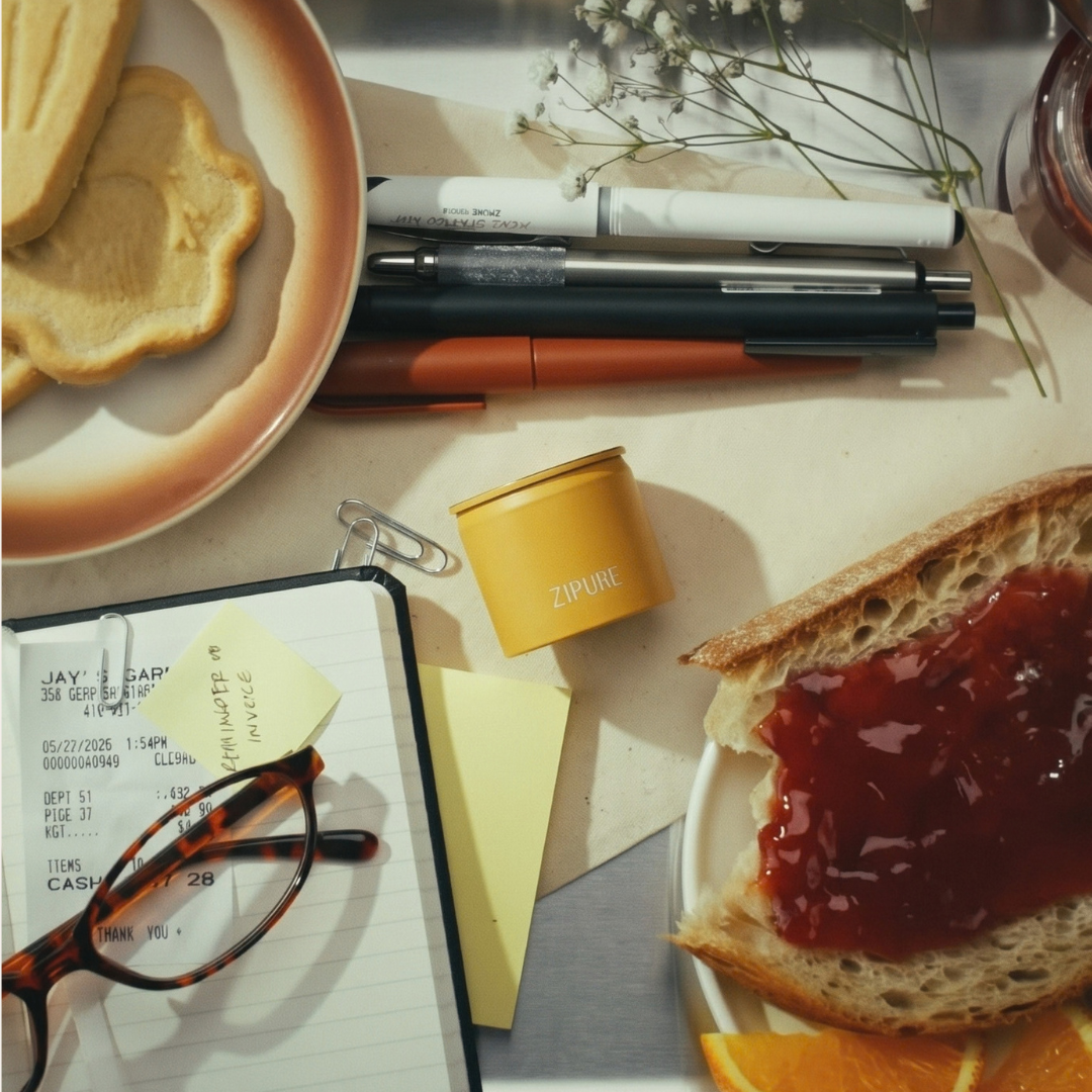 ZIPURE coffee pod styled on a desk with breakfast, stationery, and a notebook